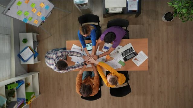 Top view of office boardroom. Moment of team building with boss cheering chant hands together on meeting. Business infographic over video.