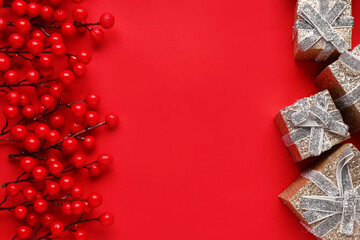 Frame made of berries and Christmas gifts on red background