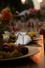 Vertical photo. Table with food and drinks. Empty wine glass. Richly decorated table. Fruit plate. Grapes, apple, pomegranate. Street fair. Celebrating Tbilisoba holiday. Day of city Tbilisi, Georgia