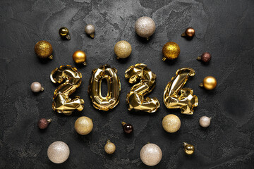 Figure 2024 made of foil balloons with Christmas decorations on black grunge background