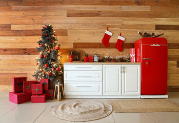 White kitchen counter and fridge with Christmas decor near wooden wall