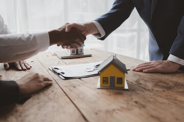 Real estate and housing sales are organized in the project, housing project salespeople explain the details of house sales, shaking hands with employees and customers after signing the sales contract. - obrazy, fototapety, plakaty