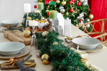 Christmas setting with burning candles on dining table in kitchen, closeup