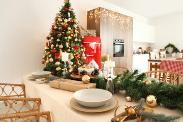 Dining table with Christmas setting and candles in kitchen