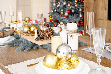 Christmas setting with burning candles on dining table in kitchen, closeup