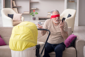 Old man looking after newborn at home