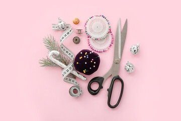 Sewing supplies with Christmas decor on pink background