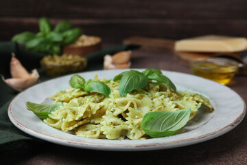 Delicious pasta with pesto sauce and basil on table, closeup. Space for text