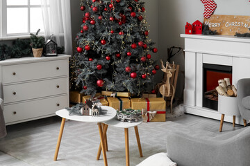 Interior of living room with Christmas tree, chest of drawers and coffee table