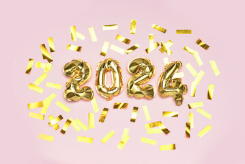 Golden foil balloons number 2024 and confetti on pink background. New year concept.