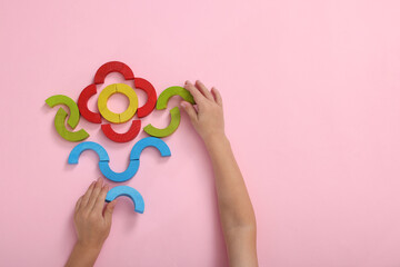 Motor skills development. Boy playing with colorful wooden arcs at pink table, top view. Space for text