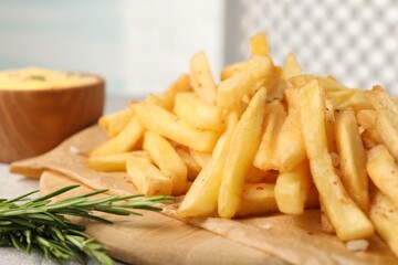 Delicious french fries with rosemary on table, closeup