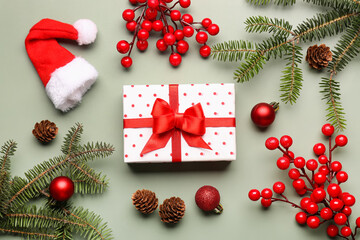 Christmas tree branches with gift box, balls and rowan on grey background