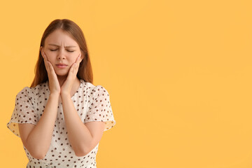 Young woman with toothache on yellow background