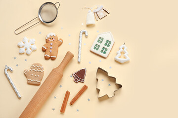 Tasty Christmas gingerbread cookies, baking mold and rolling pin on beige background