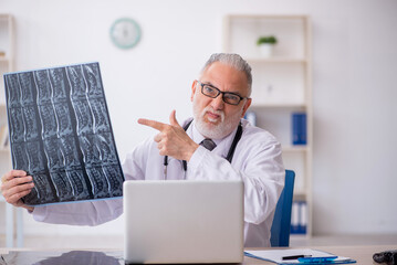 Old male doctor radiologist working in the clinic