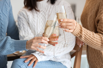 Young women with champagne celebrating Christmas in kitchen, closeup