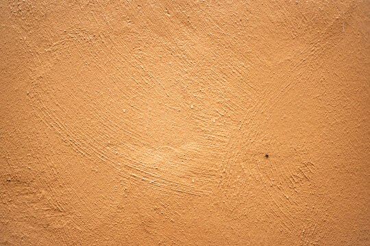 Mur de fa&ccedil;ade cr&eacute;pi et peint en brun orang&eacute;.