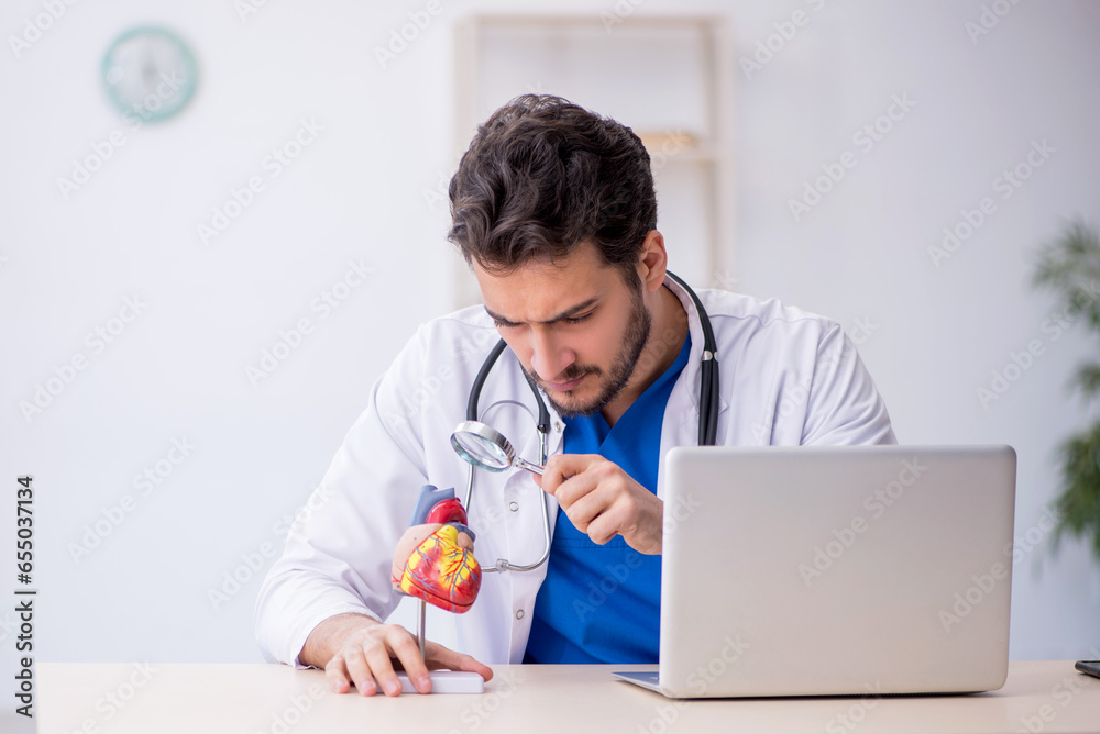 Sticker Young male doctor cardiologist working in the clinic