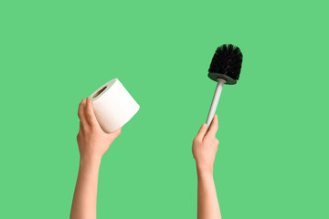 Woman with toilet paper roll and brush on green background
