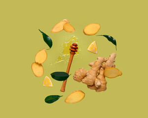 Flying slices of fresh ginger root and dipper with honey on green background