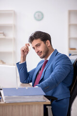 Naklejka premium Young male employee feeling bad at workplace