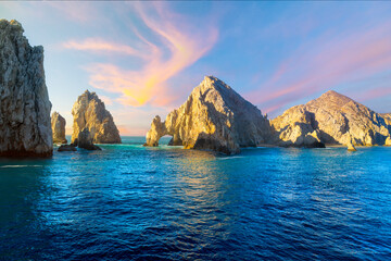 The El Arco Arch bathed in colorful light at sunset at the Land's End rock formations on the Baja...