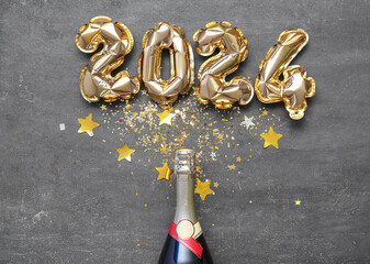 Composition with figure 2024 made of foil balloons and bottle with champagne on grey background