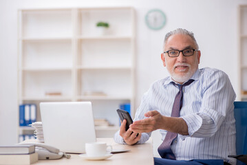 Old male employee working in the office