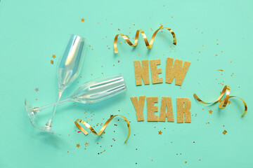 Text NEW YEAR with glasses and confetti on turquoise background