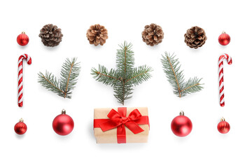 Christmas tree branches with gift box, cones and decor on white background