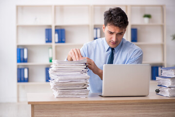 Young male employee and too much work in the office