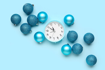 Composition with alarm clock and beautiful Christmas balls on color background