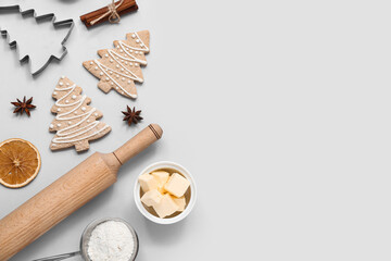 Fototapeta na wymiar Tasty Christmas cookies, ingredients and utensils on grey background
