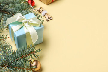 Christmas gift, decorations and fir branches on color background