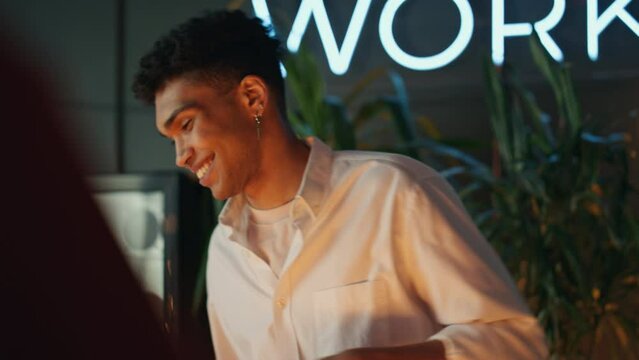Afro bartender pouring champagne at night club closeup. Waiter preparing order
