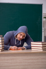 Young male student sitting in the classroom