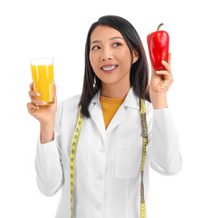 Female Asian nutritionist with bell pepper and juice on white background