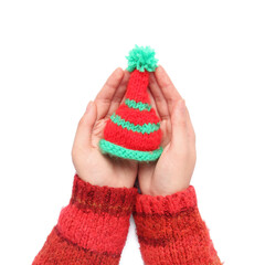 Female hands with small knitted hat on white background, closeup