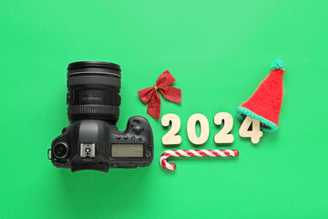 Figure 2024 with Christmas decor and photo camera on green background