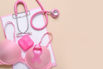 Bra with awareness ribbon, pill box, stethoscope and clipboard on beige background. Breast cancer concept