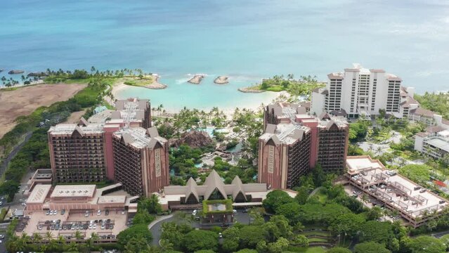 Palm trees exotic travel paradise 4K. Cinematic aerial luxury beachfront hotel. Drone view family hotel with scenic blue beach lagoon. Top down on Ko Olina resorts on Oahu island Hawaii USA tourism