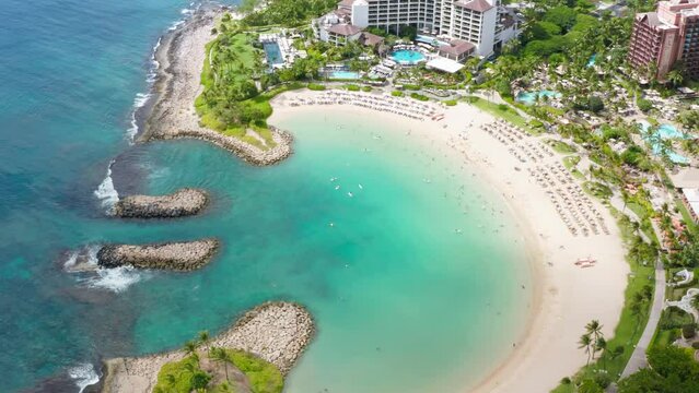 Drone view family hotel with scenic blue beach lagoon. Top down on Ko Olina resorts on Oahu island Hawaii USA tourism. Palm trees exotic travel paradise 4K. Cinematic aerial luxury beachfront hotel