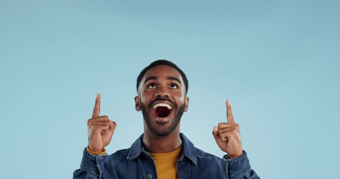Shocked man, pointing and news announcement with wow in studio, surprise emoji and advertising. Mockup, mexican person and smiling in casual fashion for offer and notification by blue background