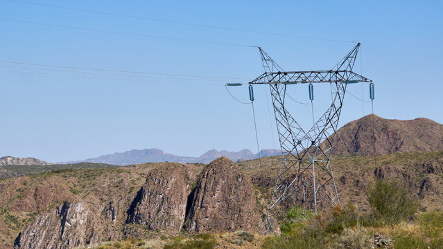 Solitary High Voltage Power Tower Amidst Breathtaking Mountain Scenery