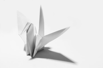 White origami paper bird on white background
