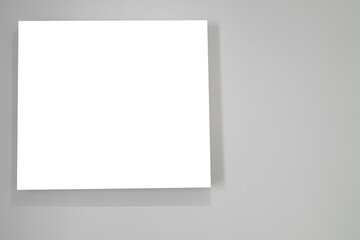 White square photo frame on the white wall background.