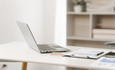 Close-up of office workspace with meticulously arranged financial bar charts, line graphs on debt...