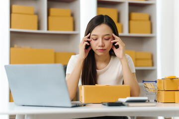 Fail and stress Asian businesswoman, visibly strained, navigates the rush of packing products, each inbox message signaling both success and mounting pressure in her SME journey.