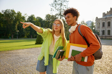 Students gossiping together standing at university campus backyard